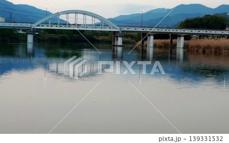 静かな川面に映るアーチ橋と山並みのリフレクション風景 静かな川面に映るアーチ橋と山並みのリフレクション風景 139331532