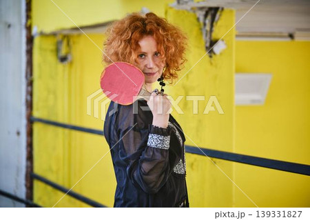 Red haired woman with ping pong paddle lifestyle portrait 139331827