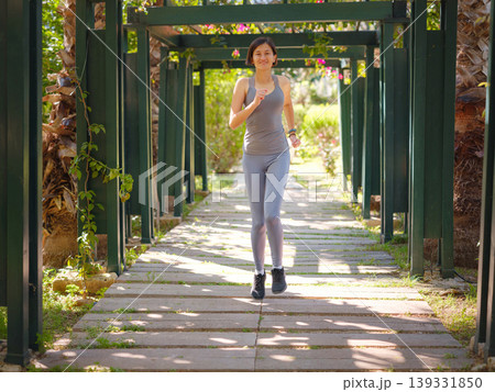 idea of healthy lifestyle and sports in a modern city. Female jogger. Fit young Asian woman running in park and enjoying healthy outdoor. Fitness girl in public park. 139331850