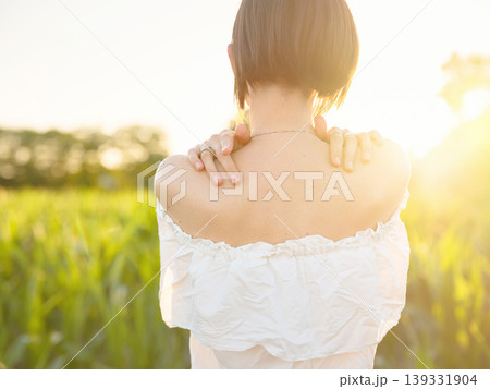 Beautiful woman in white dress standing in summer field during golden sunset in Croatia, warm sunlight, romantic evening mood, natural countryside atmosphere, soft wind and peaceful scene Beautiful woman in white dress standing in summer field during golden sunset in Croatia, warm sunlight, romantic evening mood, natural countryside atmosphere, soft wind and peaceful scene 139331904