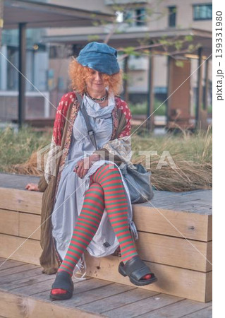 Fashionable redhead woman using smartphone outdoors, stylish young female sitting in urban environment 139331980