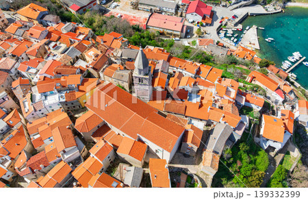 Drone captures stunning top view of Baska towns on Krk Island in Croatia. Blue Adriatic Sea meets rocky coastline and traditional Mediterranean architecture from above. Drone captures stunning top view of Baska towns on Krk Island in Croatia. Blue Adriatic Sea meets rocky coastline and traditional Mediterranean architecture from above. 139332399