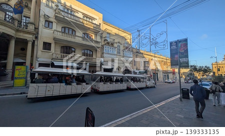 View of a tourist train running through the main street of Gozo island View of a tourist train running through the main street of Gozo island 139333135