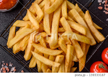 Crispy, fresh, golden French fries with salt, unhealthy takeaway food. French fries Crispy, fresh, golden French fries with salt, unhealthy takeaway food. French fries 139333187