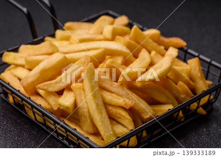 Crispy, fresh, golden French fries with salt, unhealthy takeaway food. French fries Crispy, fresh, golden French fries with salt, unhealthy takeaway food. French fries 139333189