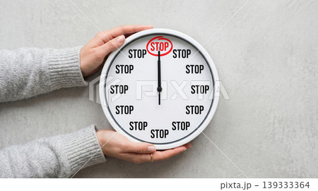 Female Hands Holding Clock with STOP Text Bad Habit Control Concept 139333364