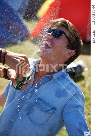 Music festival, alcohol and man with beer outdoors splash for drunk party, celebration and camp event. Happy, excited and person with beverage spray at musical concert for freedom, wild and games 139333544