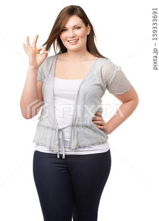 Portrait, perfect or ok with a plus size woman in studio isolated on a white background for feedback. Fashion, hand gesture and a happy young body positive model looking confident with her review 139333691