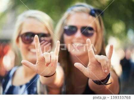 Rock, hands or portrait of friends in music festival on holiday vacation together to relax with smile. Party, reunion celebration or excited gen z women with devil horns for a fun memory or event 139333768
