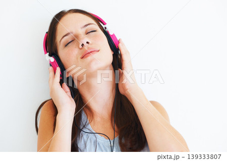 Woman, peace and listening to music on headphones to relax with sound in white background of studio. Radio, podcast or person streaming a jazz, album or hear audio of song playing with technology Woman, peace and listening to music on headphones to relax with sound in white background of studio. Radio, podcast or person streaming a jazz, album or hear audio of song playing with technology 139333807