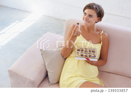 Pregnant woman, eating chocolate and relax in home, alone and happiness for delicious pregnancy craving. Good mood, comfort food and candy dessert for maternity, snack and sweet tooth satisfaction Pregnant woman, eating chocolate and relax in home, alone and happiness for delicious pregnancy craving. Good mood, comfort food and candy dessert for maternity, snack and sweet tooth satisfaction 139333857