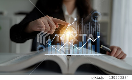 Businesswoman Analyzing Data Trends with Lightbulb Graphic Overlaid on Open Book Representing Innovative Ideas and Growth Potential Scalp Businesswoman Analyzing Data Trends with Lightbulb Graphic Overlaid on Open Book Representing Innovative Ideas and Growth Potential Scalp 139333884