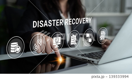 Professional Businesswoman Engaging with Disaster Recovery Software on Touchscreen Laptop in Modern Office Setting with Digital Icons Ledger 139333994