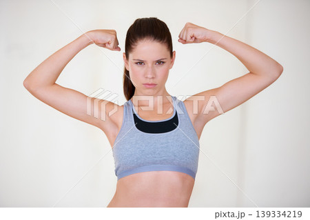 Woman, portrait or serious in studio with flex for fitness, wellness or workout strength with sportswear. Person, athlete or pride for biceps, exercise or training on white background or mockup space 139334219