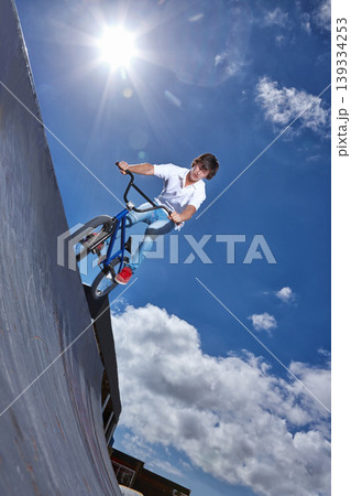 Ride, bike and teen on ramp for sport performance, jump or training for event at park with blue sky mockup. Bicycle, stunt or kid balance on edge of board in trick for cycling competition challenge Ride, bike and teen on ramp for sport performance, jump or training for event at park with blue sky mockup. Bicycle, stunt or kid balance on edge of board in trick for cycling competition challenge 139334253