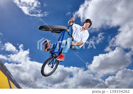 Trick, jump and man with bike in sky at park, event or competition for sport with risk, energy or freedom. Mockup, space or person in air with fearless stunt on bicycle for fun adventure in summer Trick, jump and man with bike in sky at park, event or competition for sport with risk, energy or freedom. Mockup, space or person in air with fearless stunt on bicycle for fun adventure in summer 139334262