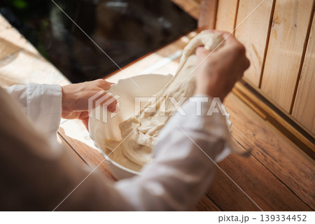 Hands of a baker making dough for bread. Girl baking bread at home Hands of a baker making dough for bread. Girl baking bread at home 139334452