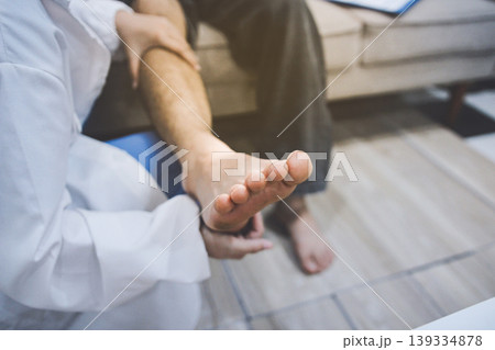 Female doctor examining male patient leg in hospital Female doctor examining male patient leg in hospital 139334878