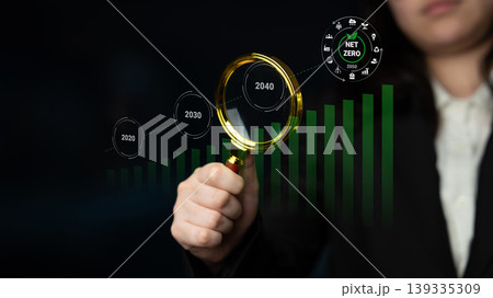 Business Professional Examining Growth Projections with Magnifying Glass and Net Zero Goals for Sustainable Future Impact Analysis Gantry 139335309