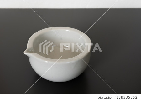 white porcelain laboratory mortar on gray background. white porcelain laboratory mortar on gray background. 139335352