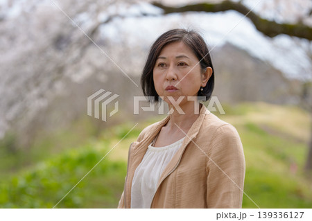桜咲く公園でたたずむシニア女性 桜咲く公園でたたずむシニア女性 139336127
