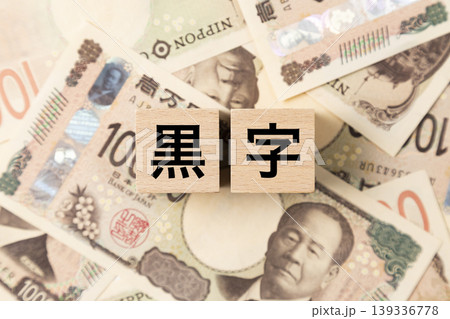 「黒字」と書かれたブロックとたくさんの一万円札 「黒字」と書かれたブロックとたくさんの一万円札 139336778