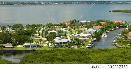 Aerial view of residential suburbs with private homes located near wildlife wetlands with green vegetation on sea shore. Living close to nature concept Aerial view of residential suburbs with private homes located near wildlife wetlands with green vegetation on sea shore. Living close to nature concept 139337575