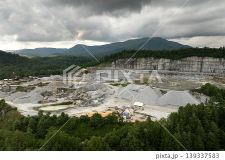 Aerial view of open pit mining site of limestone materials extraction for construction industry Aerial view of open pit mining site of limestone materials extraction for construction industry 139337583