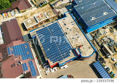 Aerial view of many photo voltaic solar panels mounted of industrial building roof. Aerial view of many photo voltaic solar panels mounted of industrial building roof. 139337596