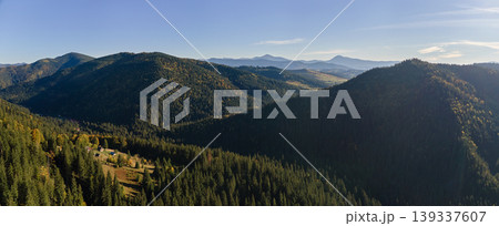 Aerial view of high hills with dark pine forest trees at autumn bright day. Amazing scenery of wild mountain woodland Aerial view of high hills with dark pine forest trees at autumn bright day. Amazing scenery of wild mountain woodland 139337607