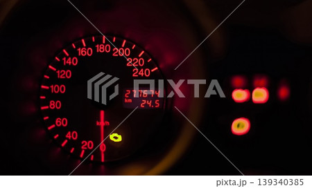 Car speedometer showing kilometers per hour and total kilometers driven at night 139340385