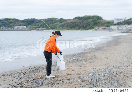 砂浜でゴミ拾いをする人 139340421