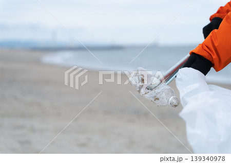 砂浜でゴミ拾いをする人 砂浜でゴミ拾いをする人 139340978