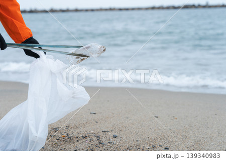 砂浜でゴミ拾いをする人 砂浜でゴミ拾いをする人 139340983