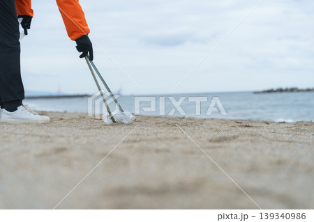 砂浜でゴミ拾いをする人 139340986