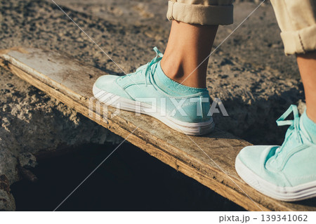 Person balancing on wooden plank 139341062