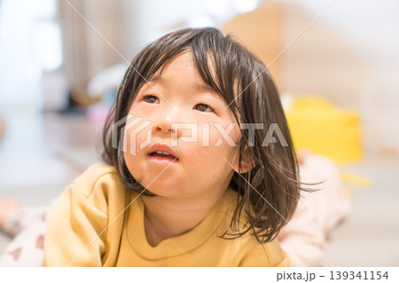 リビングで上目遣いをする日本人の女の子の幼児 139341154