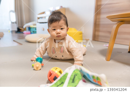 プレイマットの上でおもちゃのボールに手を伸ばす日本人の男の赤ちゃん 139341204