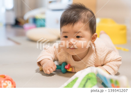 プレイマットの上でおもちゃのボールに手を伸ばす日本人の男の赤ちゃん プレイマットの上でおもちゃのボールに手を伸ばす日本人の男の赤ちゃん 139341207