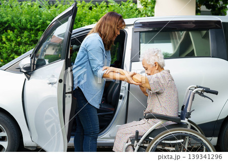 Caregiver help Asian elderly woman disability patient use wheelchair to get in car. Caregiver help Asian elderly woman disability patient use wheelchair to get in car. 139341296