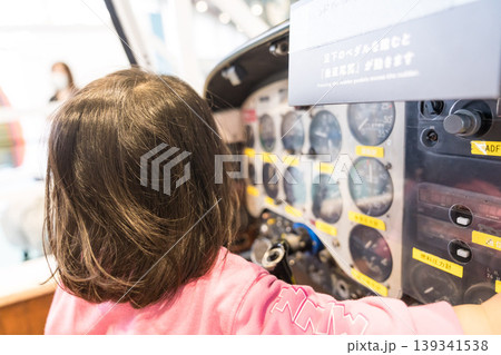 科学館の飛行機コックピット展示を操作する日本人の女の子の幼児 139341538