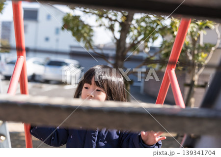 公園の滑り台を滑り降りる日本人の女の子の幼児 公園の滑り台を滑り降りる日本人の女の子の幼児 139341704