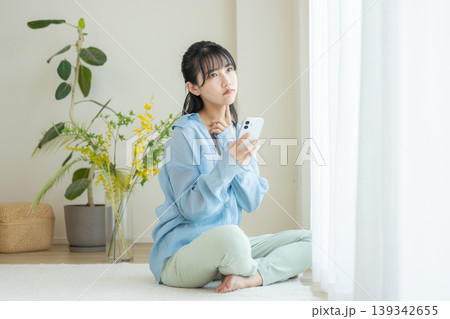 スマホを見て悩む女性 139342655