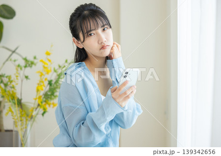 スマホを見て悩む女性 139342656