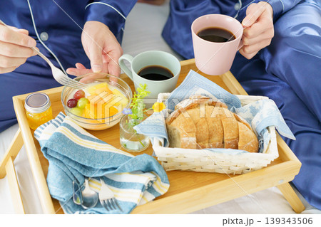 ベッドテーブルに置かれた朝食を食べる男女の手元のアップ ベッドテーブルに置かれた朝食を食べる男女の手元のアップ 139343506