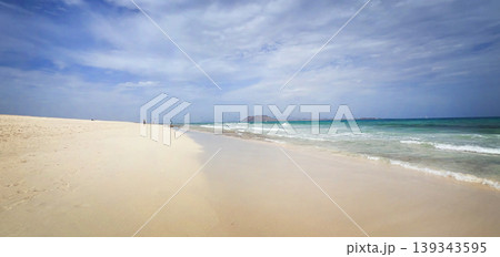 White sand beach and turquoise ocean water under cloudy sky White sand beach and turquoise ocean water under cloudy sky 139343595