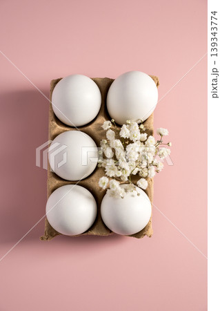Easter holiday background. White eggs and white spring Gypsophila flowers in carton box on pastel pink background. 139343774