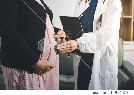 Pregnant woman having her belly examined by a doctor with a stethoscope in a clinic room highlighting a medical checkup, pregnancy health, and prenatal care Pregnant woman having her belly examined by a doctor with a stethoscope in a clinic room highlighting a medical checkup, pregnancy health, and prenatal care 139343785