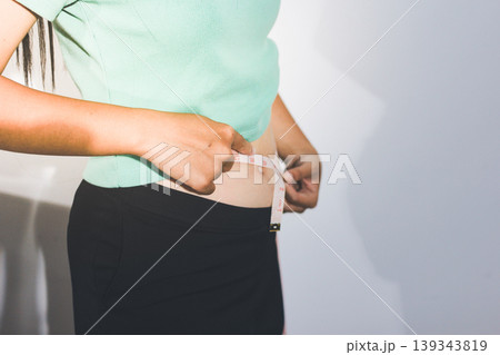Flabby belly after pregnancy, overweight female body on gray background 139343819