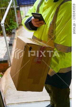 Delivery man at door entrance giving a box to a woman. Online shopping, delivery service Delivery man at door entrance giving a box to a woman. Online shopping, delivery service 139343959